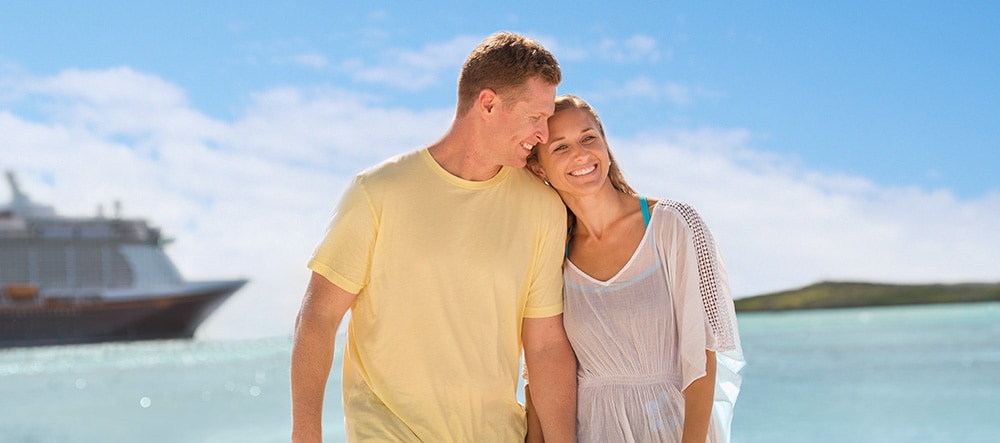 A man and woman lean in close together while standing near a cruise ship