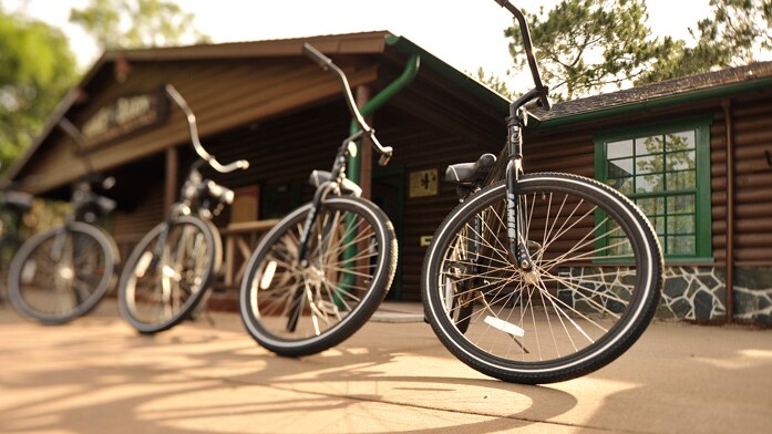 Four bicycles lined up in front of a wood building