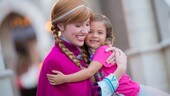A young girl hugging Princess Anna